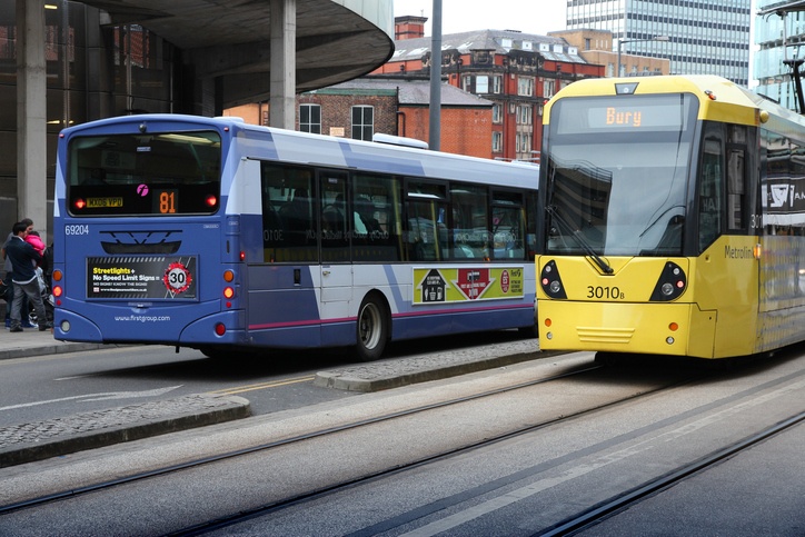 Tram passes bus in Manchester, England